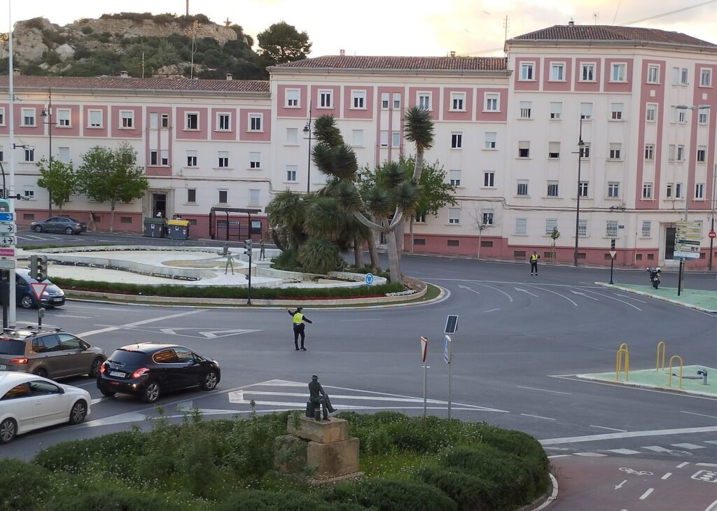Agente de policía regulando el tráfico a mano en un cruce