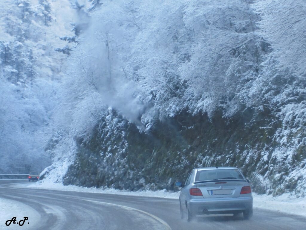 Coches circulando por una carretera nevada